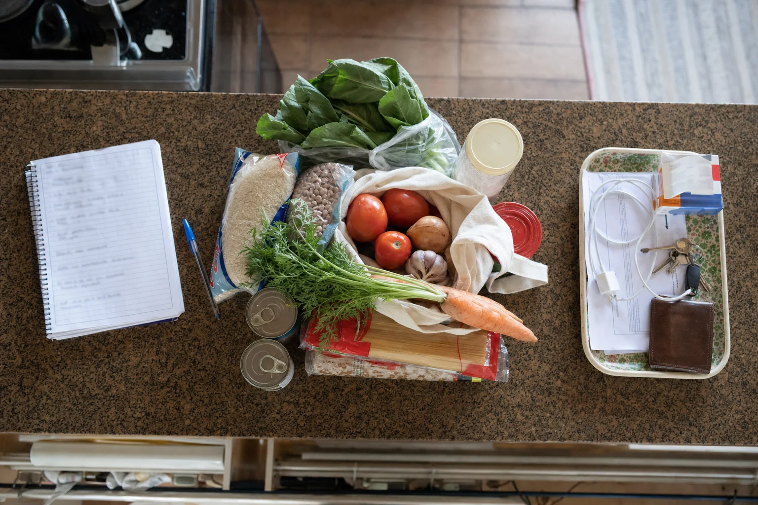 Bancada de cozinha com três zonas de preparo da semana: refeições, compras e pendências