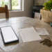 Cena doméstica realista com celular, lista curta e itens do dia a dia, ilustrando apps simples para organizar pequenas pendências.