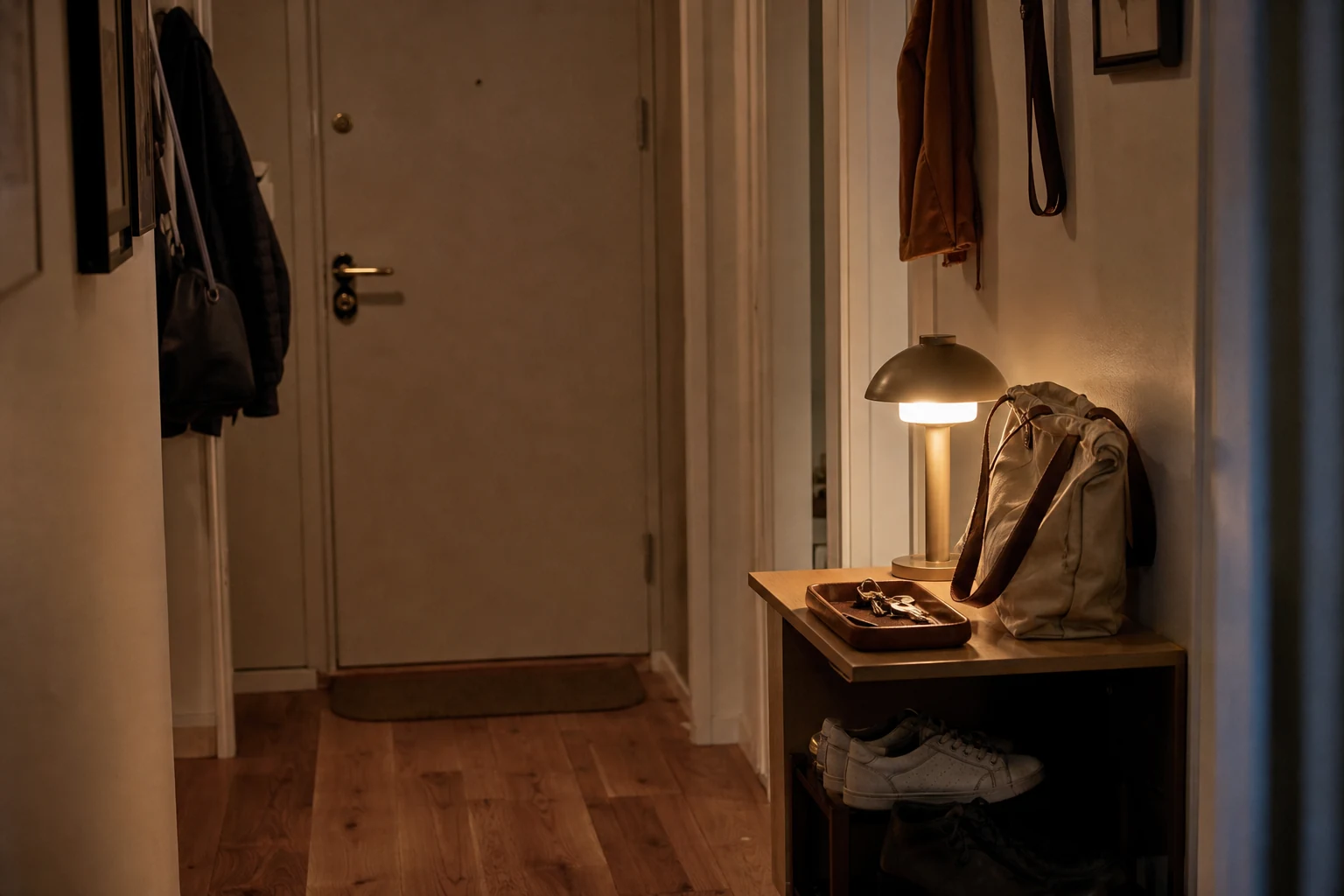 Entrada de casa organizada à noite com bolsa, chaves e sapatos já posicionados para a manhã seguinte.