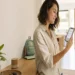 Pessoa em casa olhando o celular com poucas notificações importantes e ambiente doméstico calmo.