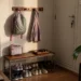 Entrada de casa organizada para a volta da escola, com mochila, casaco e sapatos em um ponto de apoio.
