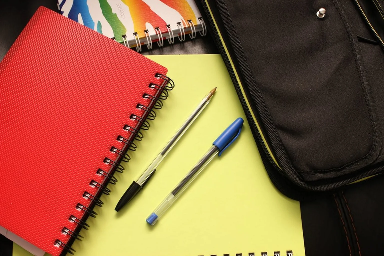 Materiais escolares organizados em bancada clara, com espaço livre para a tarefa.