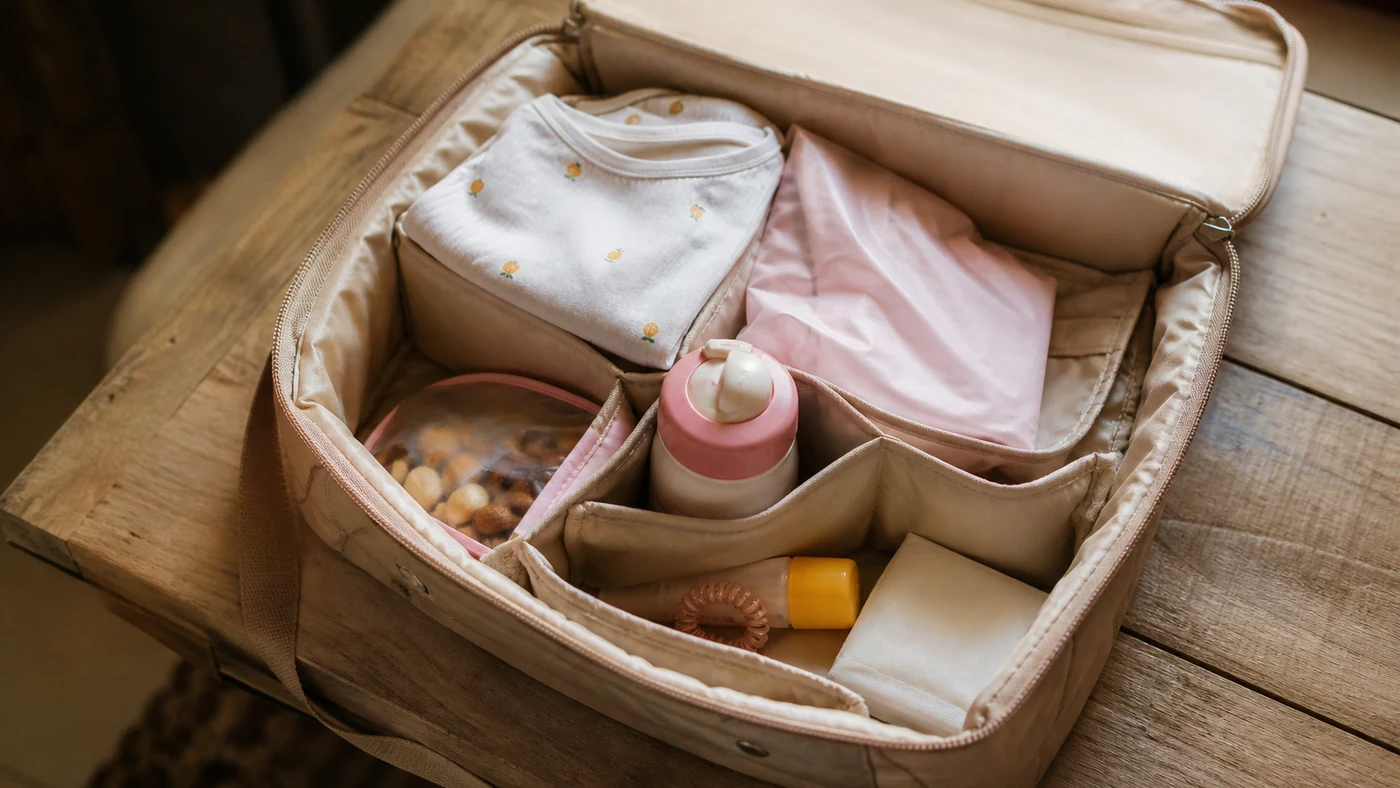 Bolsa de atividade infantil em um banco de entrada com kit fixo separado por necessaires e bolsos simples.