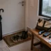 Entrada de apartamento preparada para chuva forte, com guarda-chuva, lanterna, carregador portatil, chaves e pasta de documentos.
