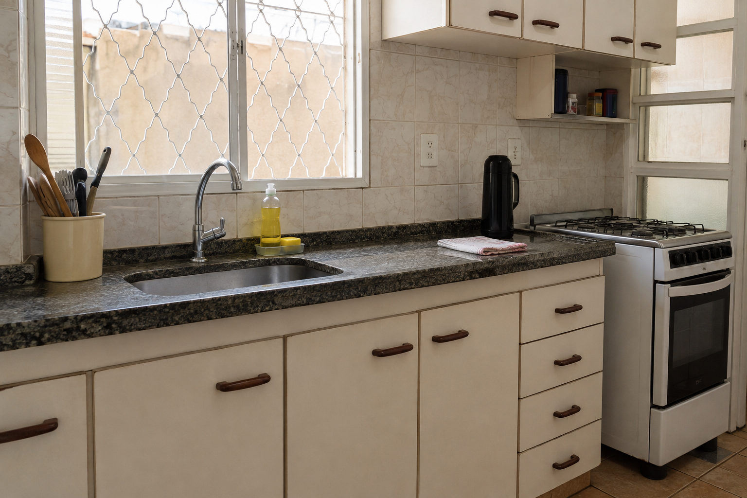 Bancada de cozinha e banheiro liberadas, com poucos itens visíveis e espaço pronto para limpeza.